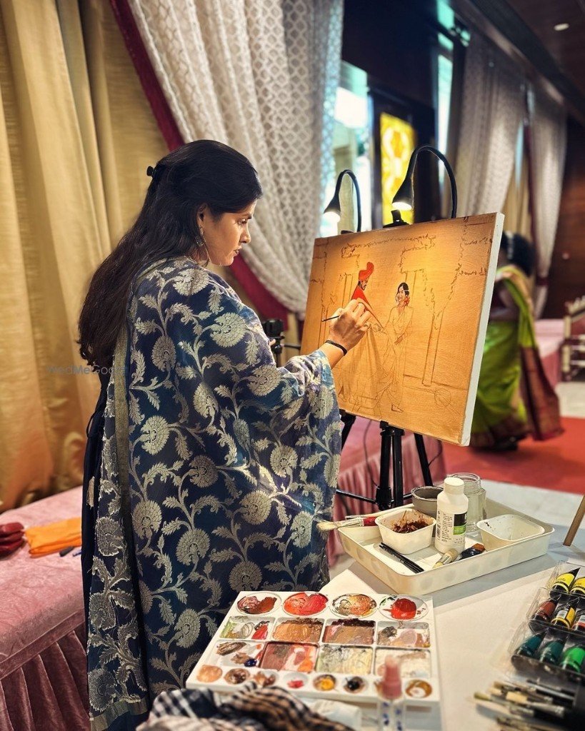 Live event painting — artist at easel with brush, canvas and palette during an elegant indoor celebration